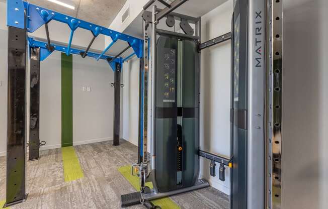 a fitness room with a treadmill and weights in the corner of a room