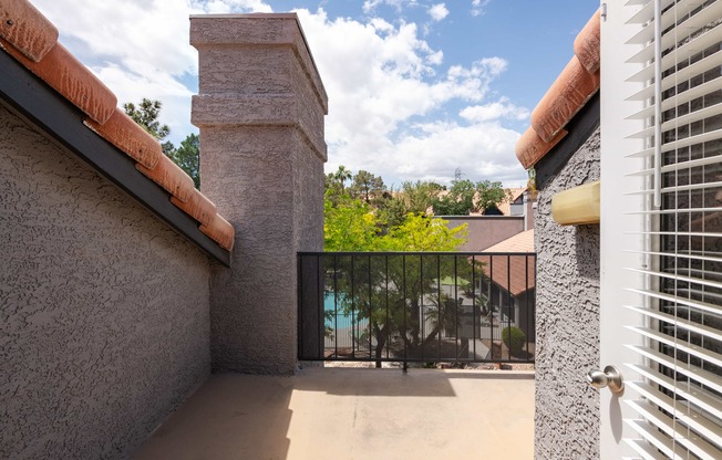 a balcony with a view of a pool and a gate