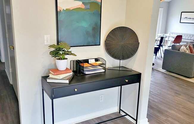 a living room with a table and a painting on the wall