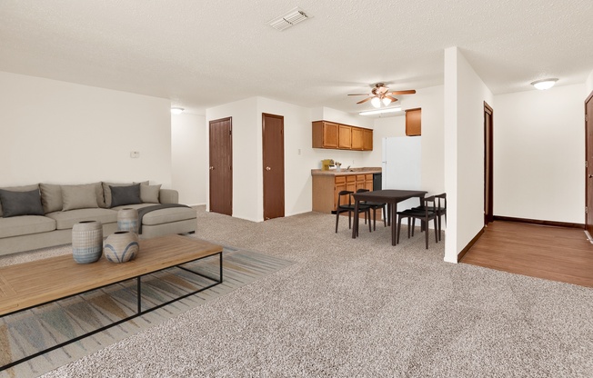 A living room with a grey carpet and a wooden coffee table.