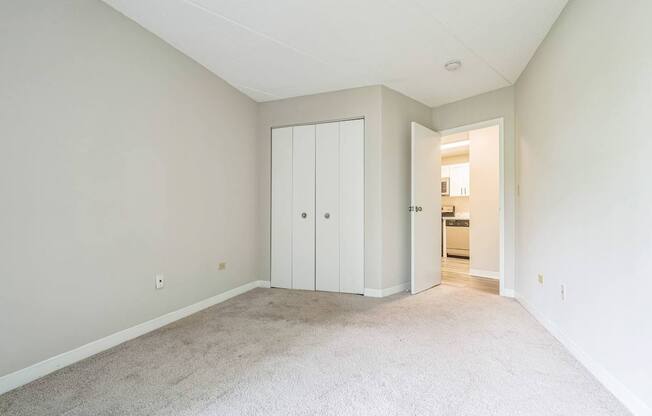 A room with a white door and a carpeted floor.