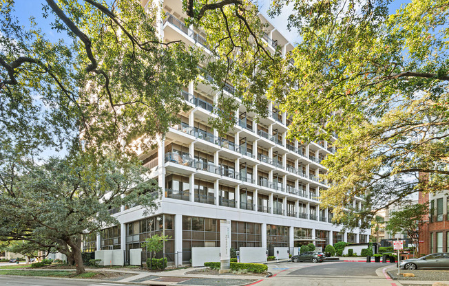 an apartment building on a city street with trees