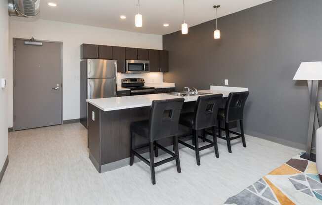 Modern open-concept kitchen and living area with stainless steel appliances.