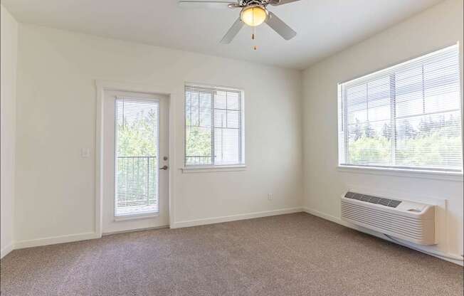 A room with a ceiling fan and a window with blinds at Riverplace Apartment Homes, Independence, OR