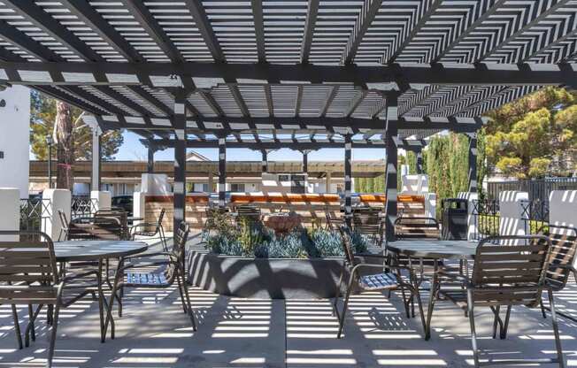 a patio with tables and chairs and a pergola