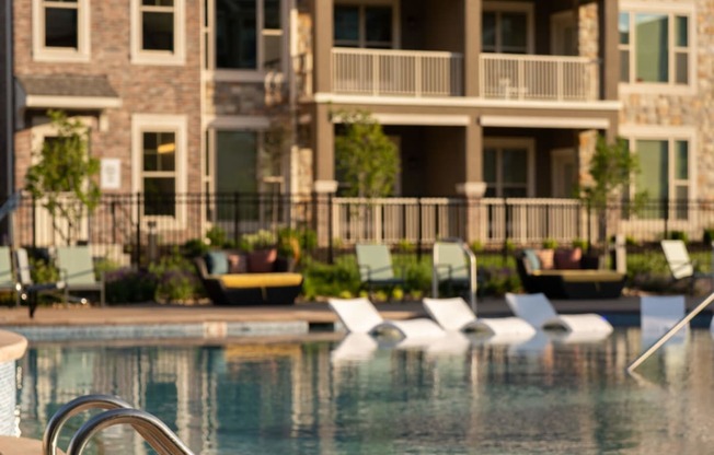 a swimming pool in front of an apartment building at The Clearing at ONE28, Olathe, Kansas