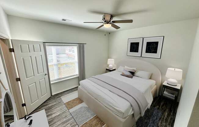 A bedroom with a bed, nightstand, and window.