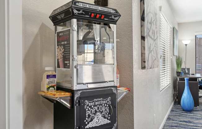 A hot buttered popcorn machine is on a table.