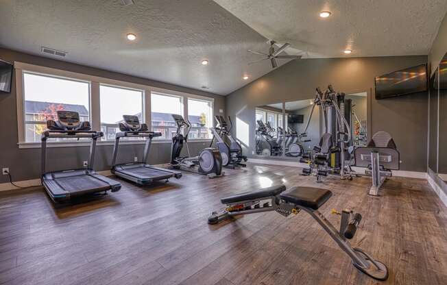 a gym with exercise equipment and windows with a view