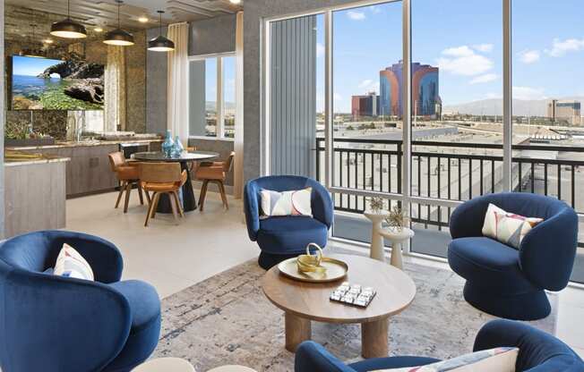 a living room with blue chairs and a view of the city at Aura Vegas Apartments, Nevada, 89103