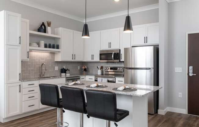 A modern kitchen with a large island and bar stools.