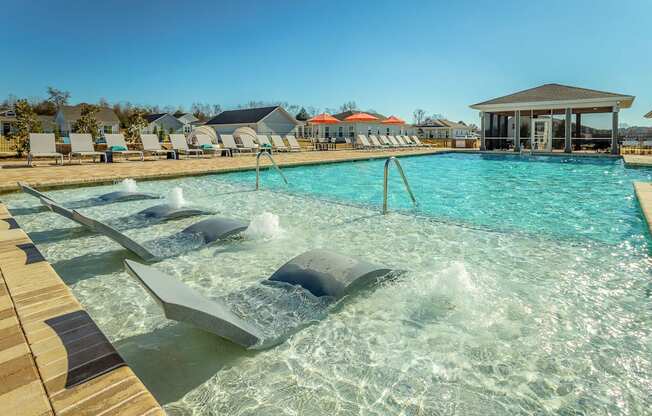 a resort style pool with chaise lounge chairs and a gazebo