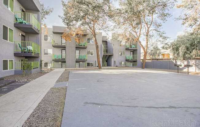 Apartment complex with green balconies and trees.