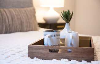 a tray with coffee cups and a vase on a bed at 511 Meeting, Charleston, 29403