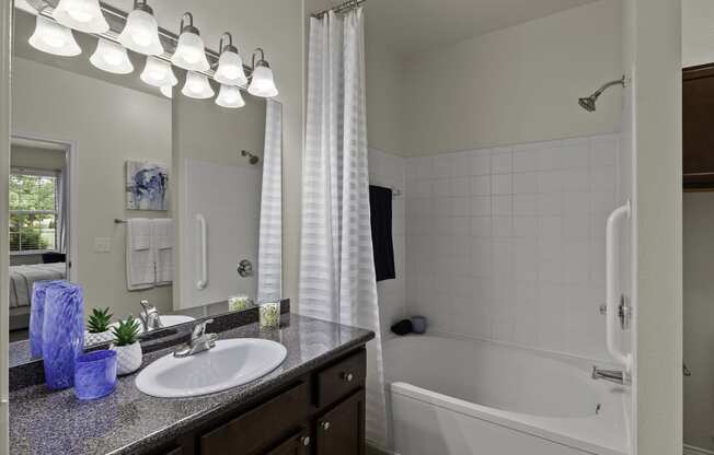a bathroom with a sink and a tub and a mirror