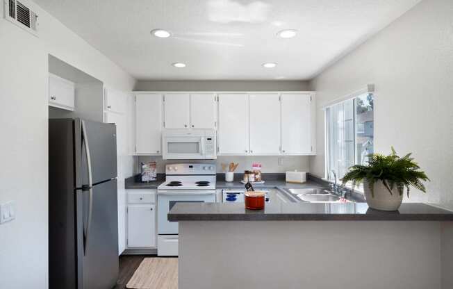 a kitchen with white cabinets and stainless steel appliances and a counter top