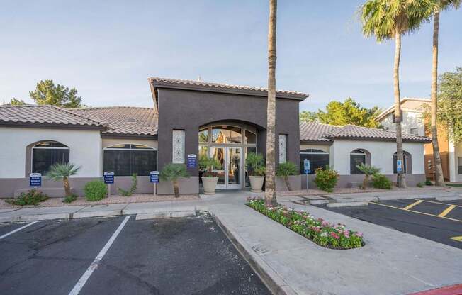 A building with a large arched entrance and a parking lot in front at Sterling Point Apartment Homes, Arizona