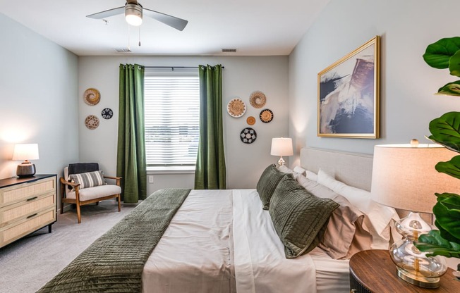 bedroom with a large bed and green curtains and a ceiling fan