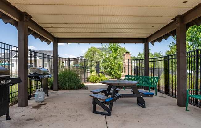 a picnic table and grill at the whispering winds apartments in pearland, tx