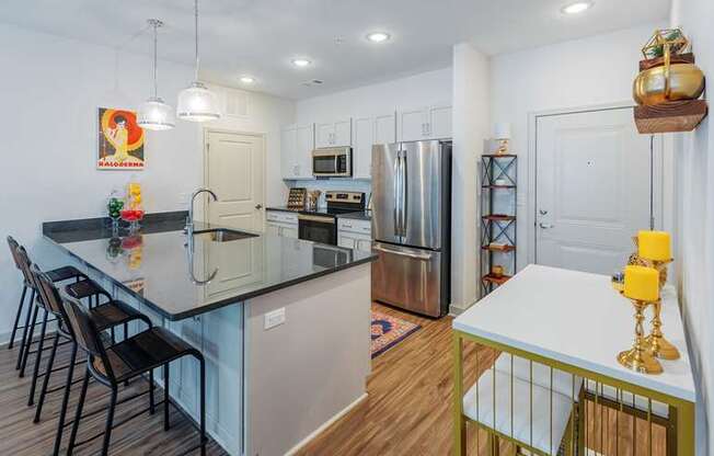 A kitchen with a black countertop and stainless steel appliances.
