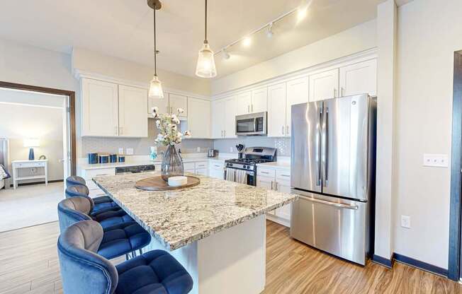A kitchen with a marble countertop and stainless steel appliances.