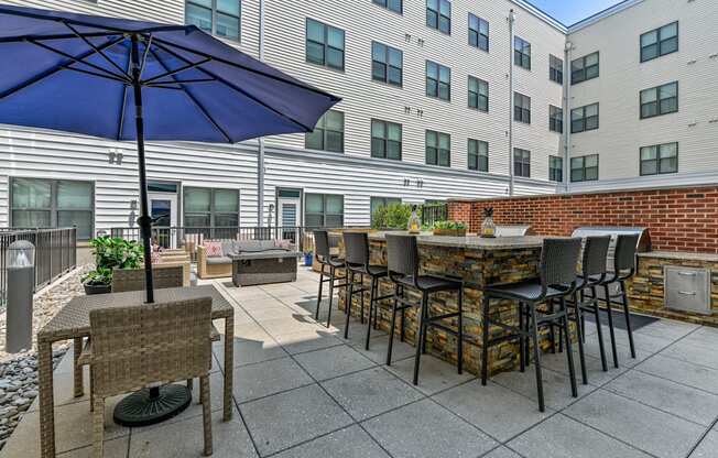 Patio with an umbrella and tables with chairs at The View at Old City, Philadelphia