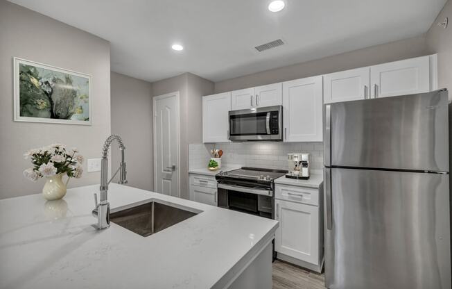 a kitchen with white cabinets and stainless steel appliances