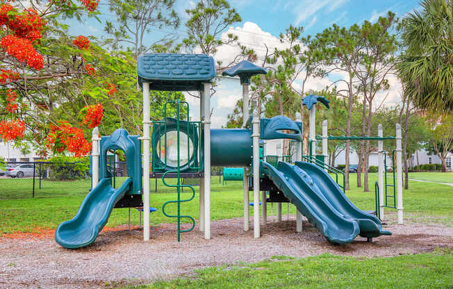 A playground with a green slide and a blue and green play structure.