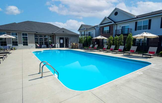 A large swimming pool in front of a building with a clear blue sky.
