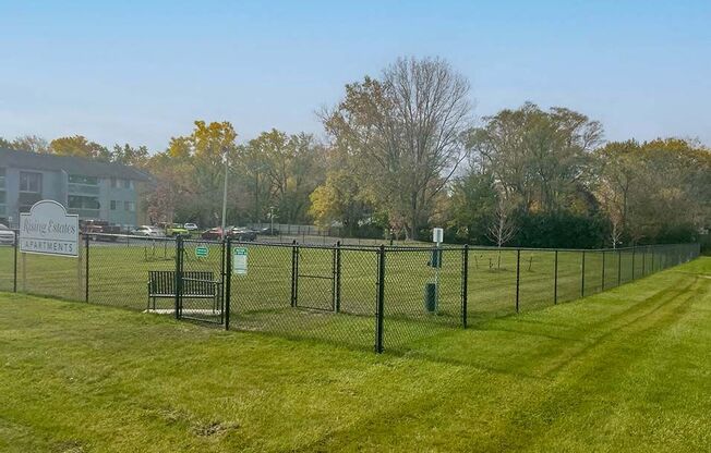 a chain link fence in a field with grass