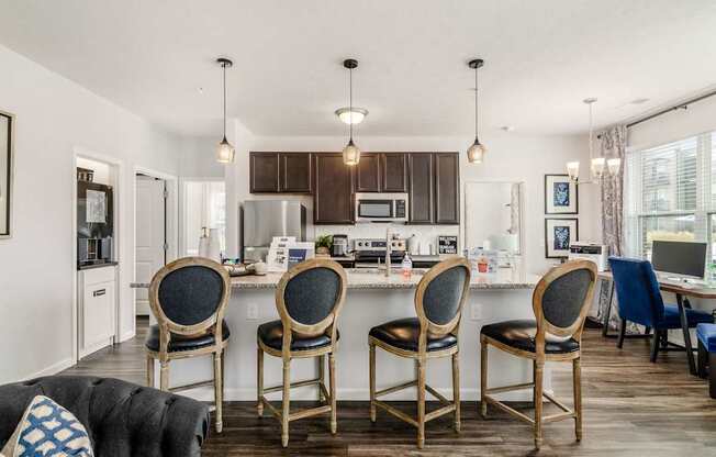A kitchen with a table and chairs in front of it.
