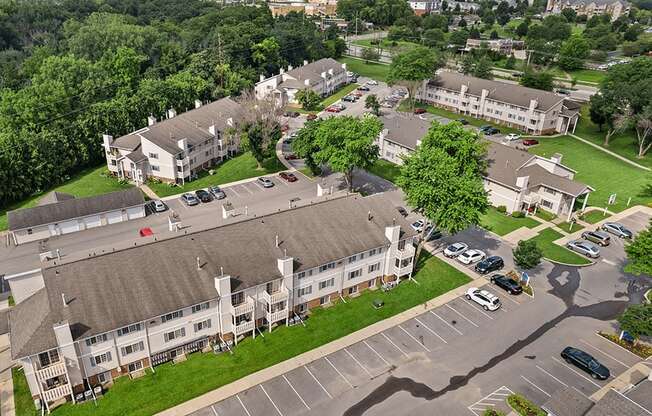 an aerial view of an apartment complex with cars parked in a parking lot