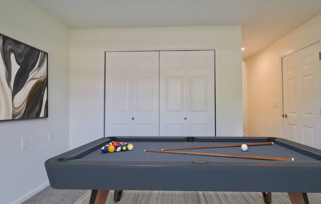 A pool table with a white ball and a set of triangular pool cues.