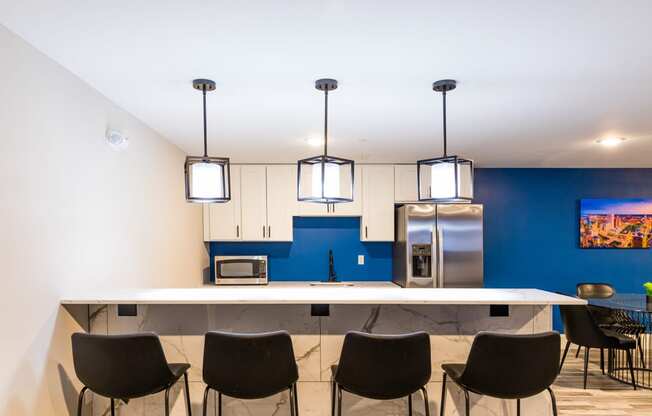 a kitchen with a blue wall and a counter with chairs