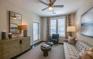 a living room with a ceiling fan and a large window