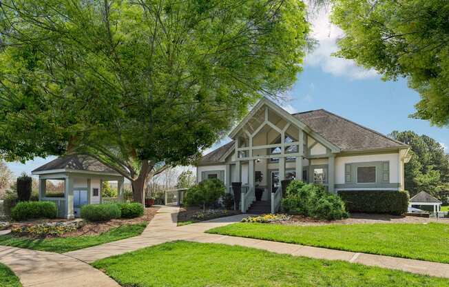 A house with a blue door and a porch is surrounded by greenery.