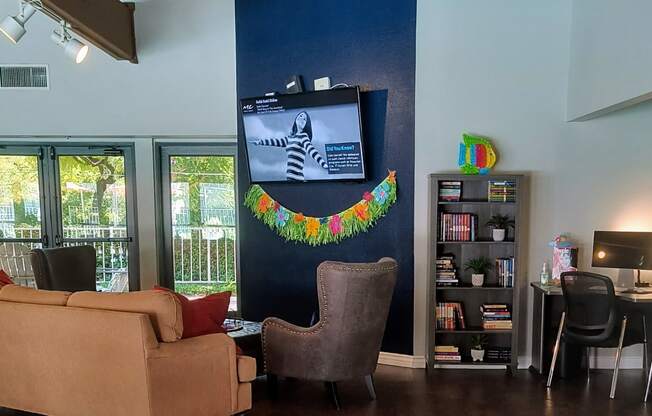 a living room with couches chairs and a tv on the wall