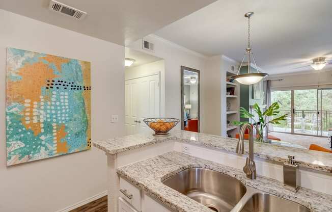 an open kitchen with a stainless steel sink and counter top