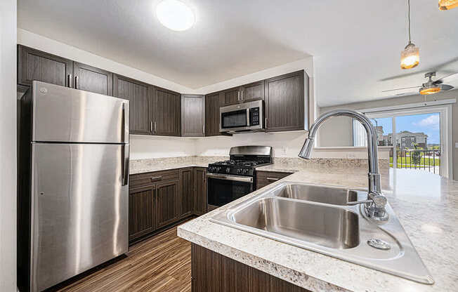 A modern kitchen with a stainless steel refrigerator at Copper Creek Apartment Homes, Maize