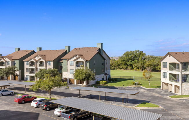 an aerial view of an apartment complex with a parking lot at The Fairways at Star Ranch, Hutto, Texas
