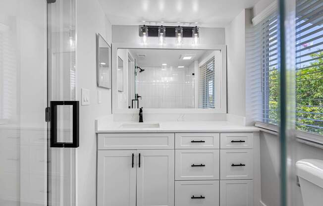A bathroom with a white cabinet and a mirror above the sink.