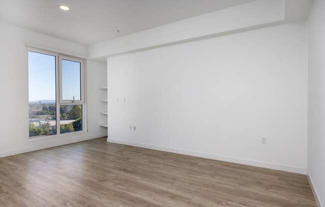 an empty room with white walls and a window