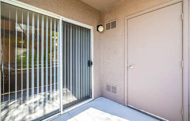 A patio with a sliding glass door and a white door at Sterling Point Apartment Homes, Arizona
