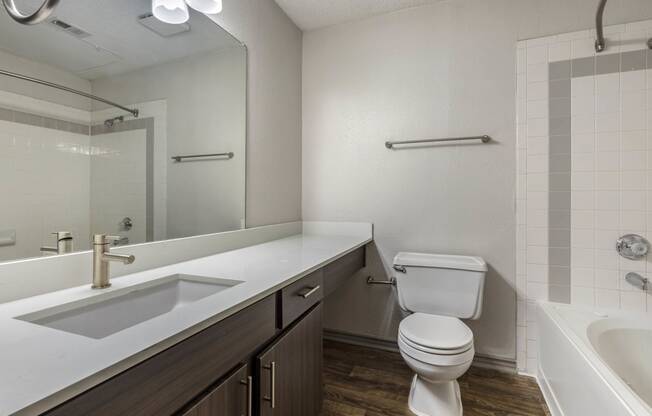 a bathroom with a toilet and a sink and a mirror at Lakeshore at Preston, Texas