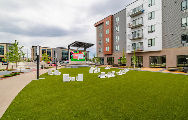 a green lawn with chairs and tables in front of an apartment building at EagleRidge Plaza Residences, North Dakota, 58104