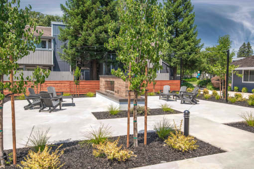 Resident courtyard with benches and trees in front of a fireplace