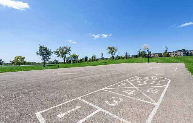 a basketball court in a park with a blue sky