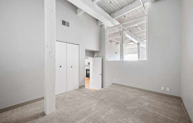 A large, empty room with a carpeted floor and white walls.