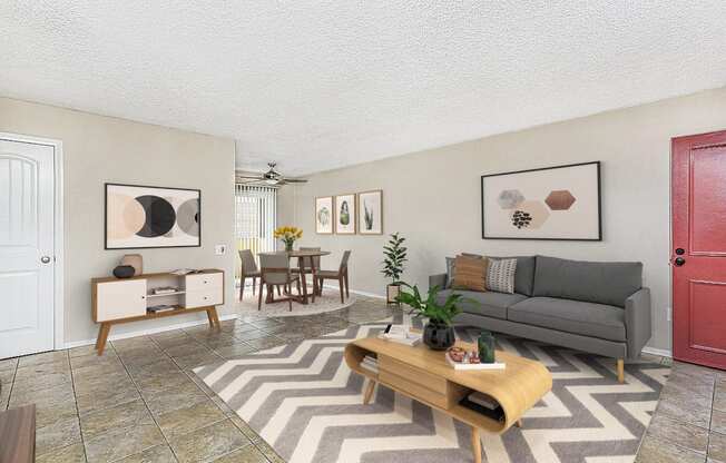 Apartment living room showing the entry door, large couch, coffee table and the dining area at Pacific Sands, San Diego, CA