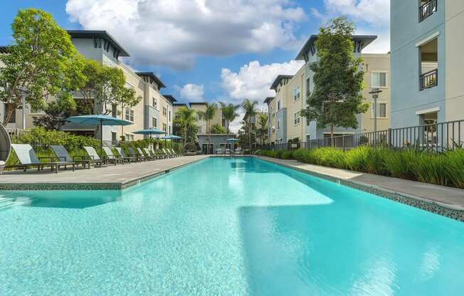 A large swimming pool in front of apartment buildings.